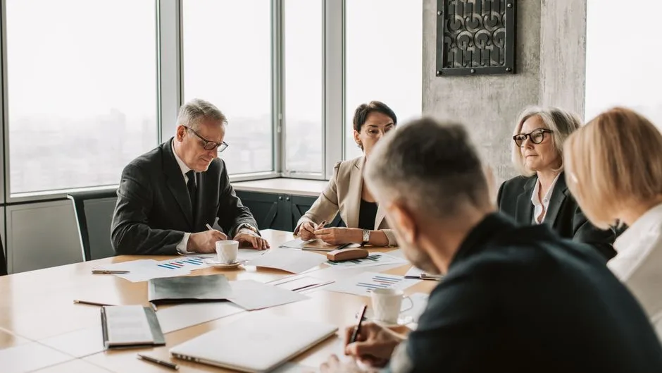 Une équipe de PME travaille une offre B2B autour d’une table, en lumière naturelle